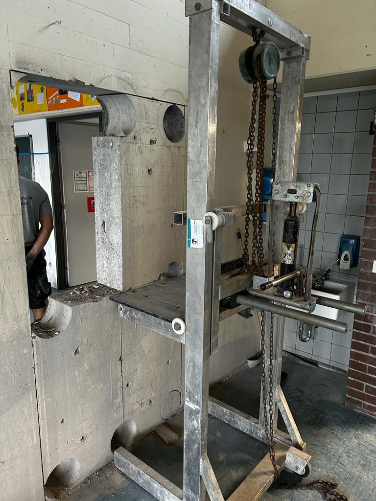 Fertig gesägter Wanddurchbruch, ausgeschnittener Betonblock wird mit Hebezug entfernt